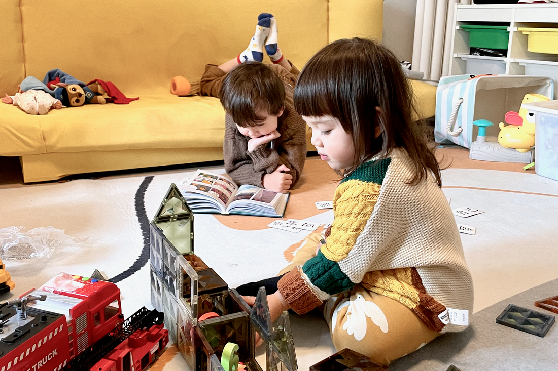 kids playing with magnetic tiles and reading in a playroom