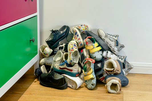 Outgrown children's shoes lined up, representing how many pairs a child goes through during early childhood